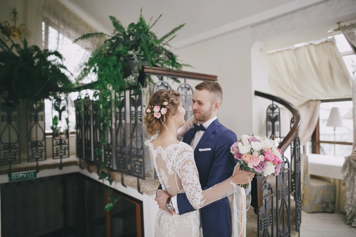 Newlyweds standing on a grand staircase
