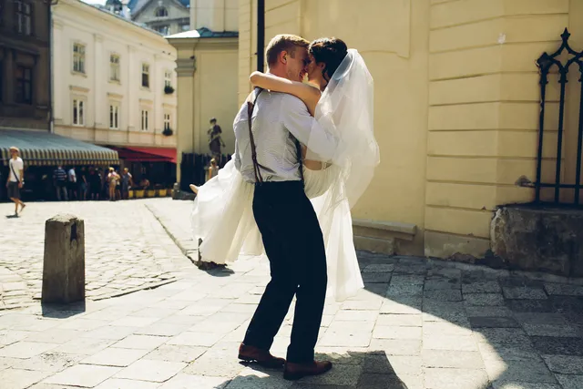 Newlyweds kissing on a city street
