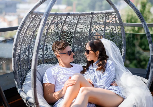 A bride and groom resting together on a balcony